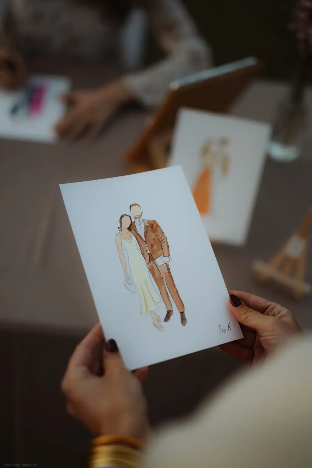 Invité récupérant le croquis de son couple réalisé à l'aquarelle (© Marion B. Photographie) Invité récupérant le croquis de son couple réalisé à l'aquarelle (© Marion B. Photographie)